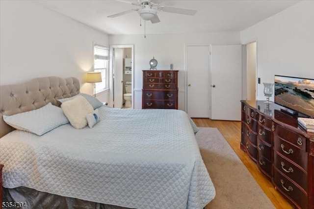 bedroom with ensuite bathroom, a ceiling fan, and light wood-style flooring