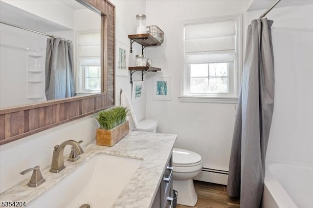 bathroom with vanity, a baseboard heating unit, toilet, and wood finished floors