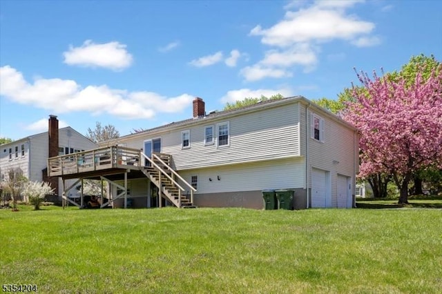 back of property with a garage, a deck, a chimney, stairs, and a lawn