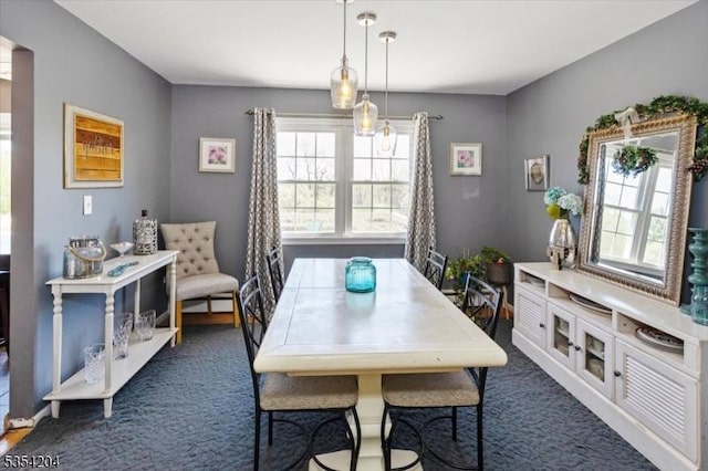 dining space with dark colored carpet