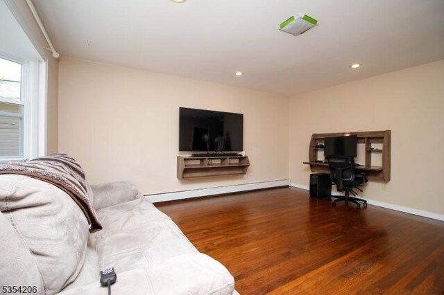 living area featuring recessed lighting, baseboards, wood finished floors, and a baseboard radiator