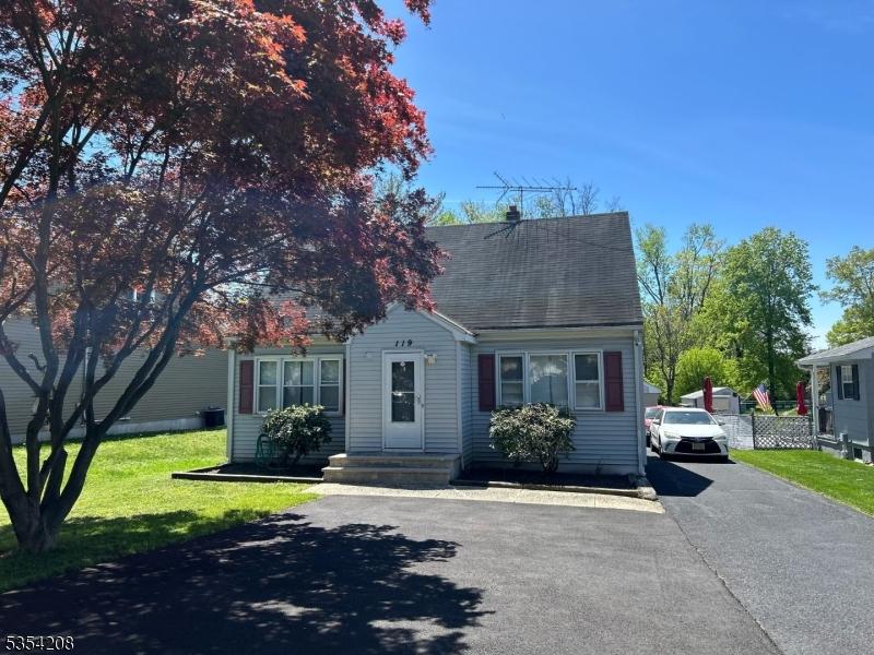 view of front facade featuring a shingled roof, aphalt driveway, and a front yard