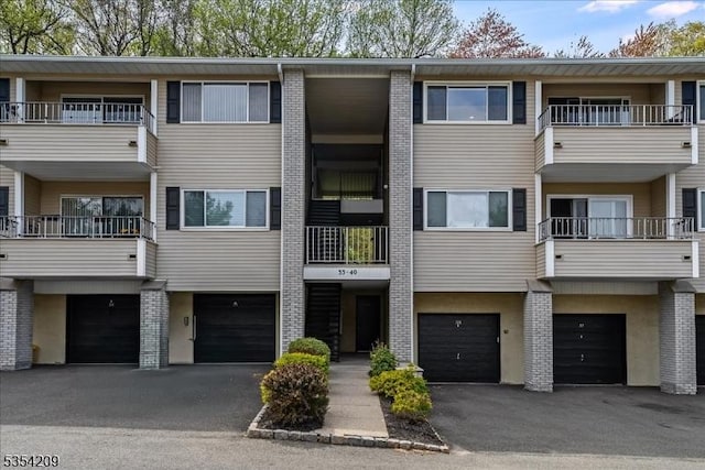 view of building exterior featuring an attached garage and driveway