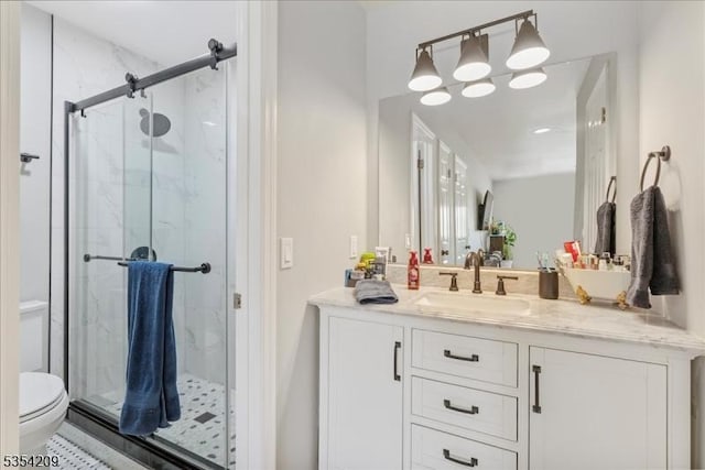 full bath featuring vanity, a marble finish shower, and toilet