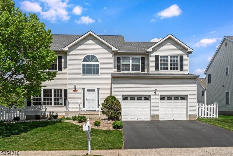 30 Murphy Dr, Bridgewater Twp, NJ 08807 - view of front of house featuring an attached garage, driveway, fence, and a front yard
