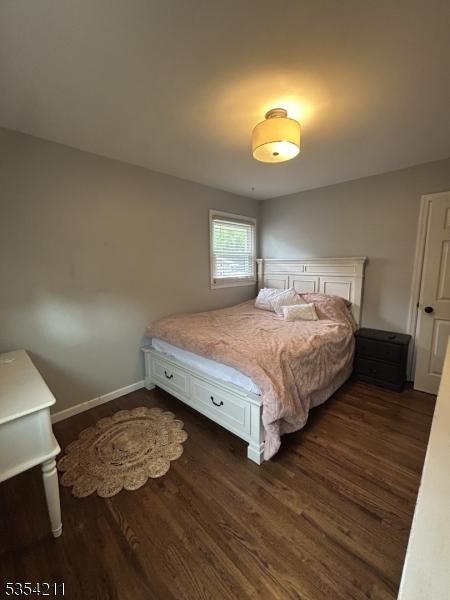 bedroom with baseboards and dark wood-style floors