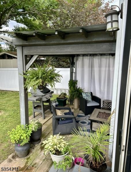 exterior space with outdoor lounge area, a wooden deck, and a grill