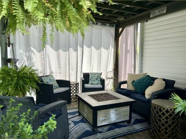 sunroom featuring an outdoor living space with a fire pit
