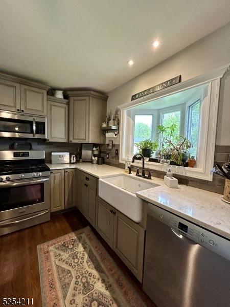 kitchen featuring a sink, dark wood finished floors, gray cabinets, stainless steel appliances, and recessed lighting