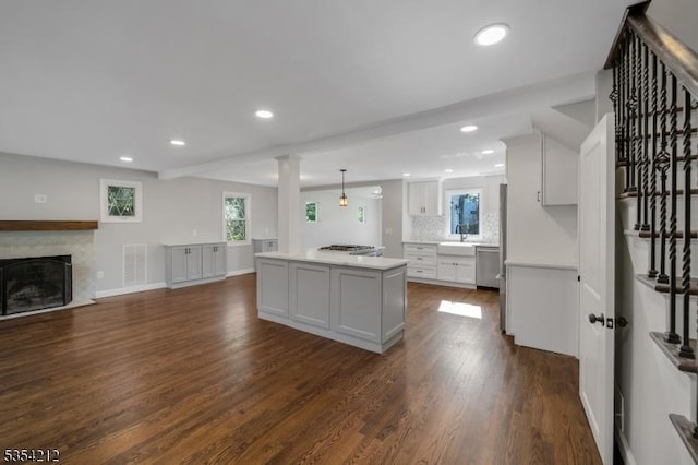 kitchen with visible vents, a center island, stainless steel dishwasher, dark wood-style floors, and recessed lighting