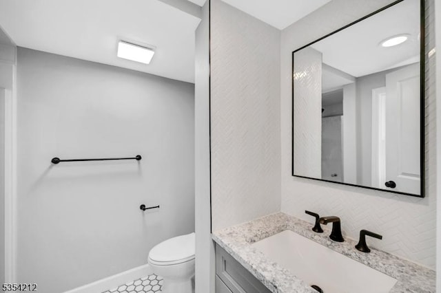 bathroom with vanity, baseboards, and toilet