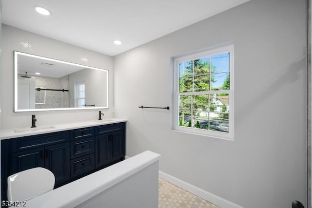 bathroom with a sink, baseboards, and a wealth of natural light