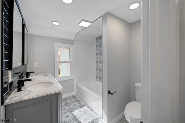 bathroom with a tub, baseboards, toilet, and a sink