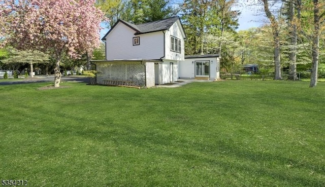 rear view of property featuring a yard