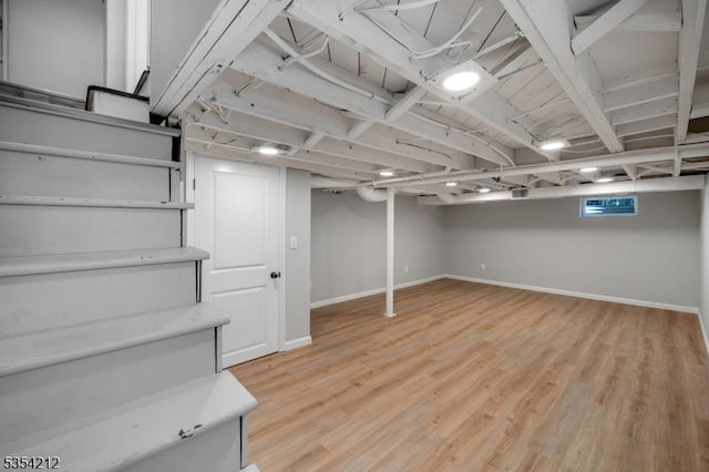 finished below grade area featuring baseboards and light wood-style floors