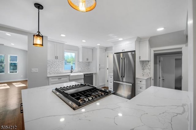 kitchen with appliances with stainless steel finishes, tasteful backsplash, baseboards, and white cabinets