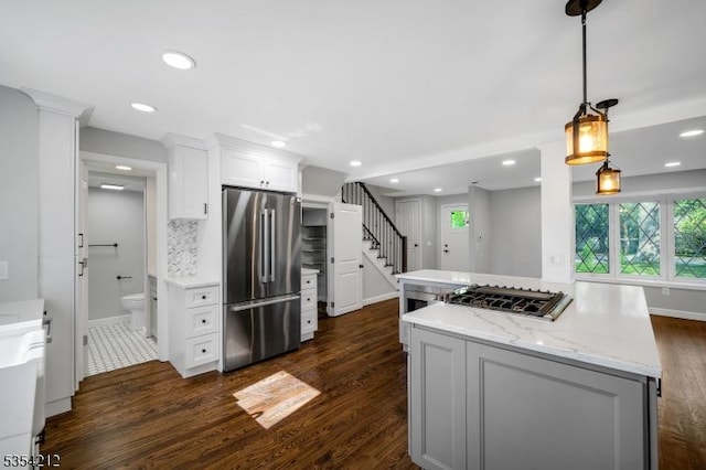 kitchen featuring appliances with stainless steel finishes, a center island, white cabinetry, and dark wood-type flooring