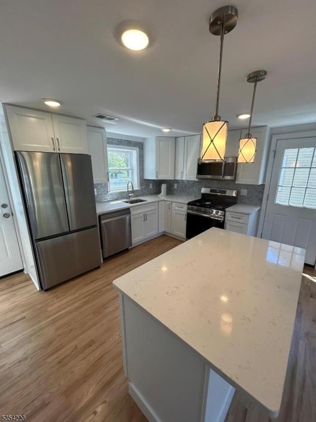 kitchen featuring visible vents, a sink, appliances with stainless steel finishes, and tasteful backsplash