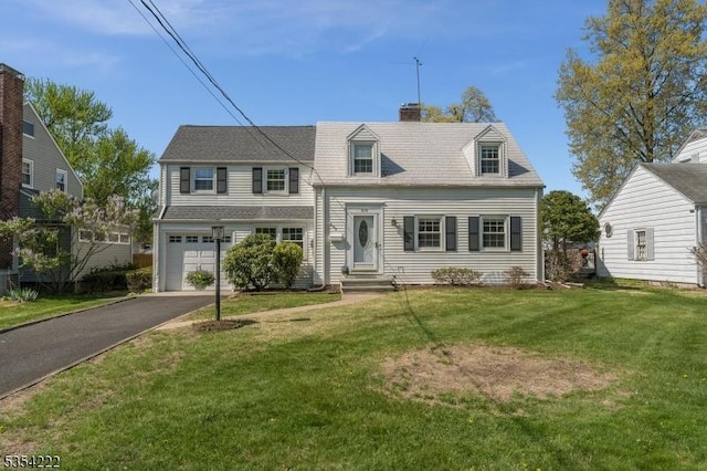 view of front of house featuring an attached garage, a chimney, driveway, and a front lawn
