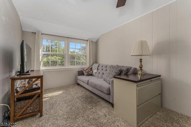 carpeted living room with ceiling fan and lofted ceiling