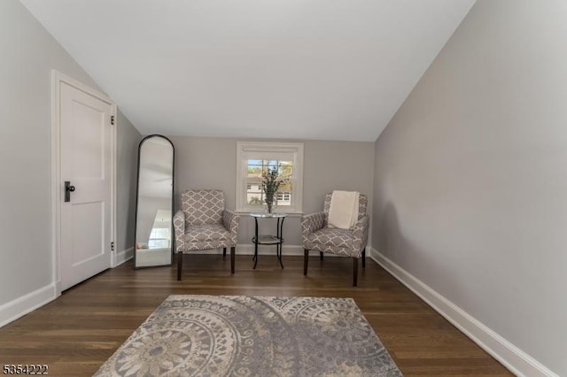 sitting room featuring baseboards, vaulted ceiling, and wood finished floors