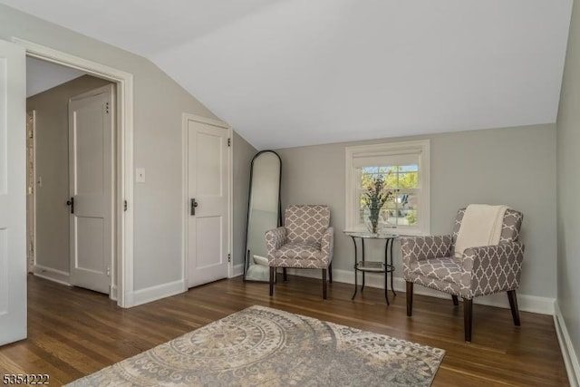 sitting room with baseboards, wood finished floors, and vaulted ceiling