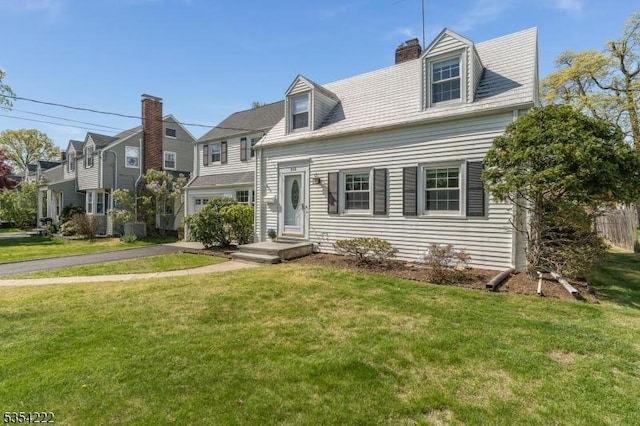view of front of house with a front lawn, aphalt driveway, and a chimney