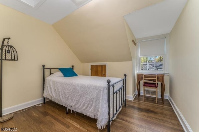 bedroom featuring baseboards, vaulted ceiling, and dark wood finished floors