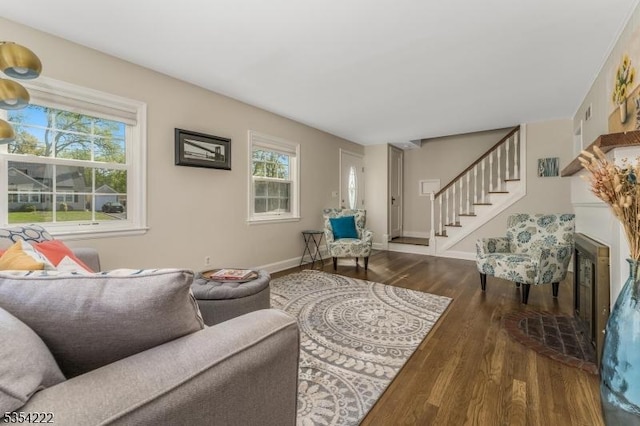 living area featuring stairway, baseboards, and wood finished floors