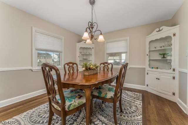 dining area featuring dark wood-type flooring, baseboards, and a wealth of natural light