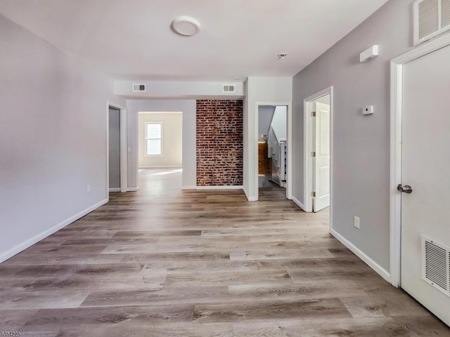 unfurnished living room featuring baseboards, wood finished floors, and visible vents