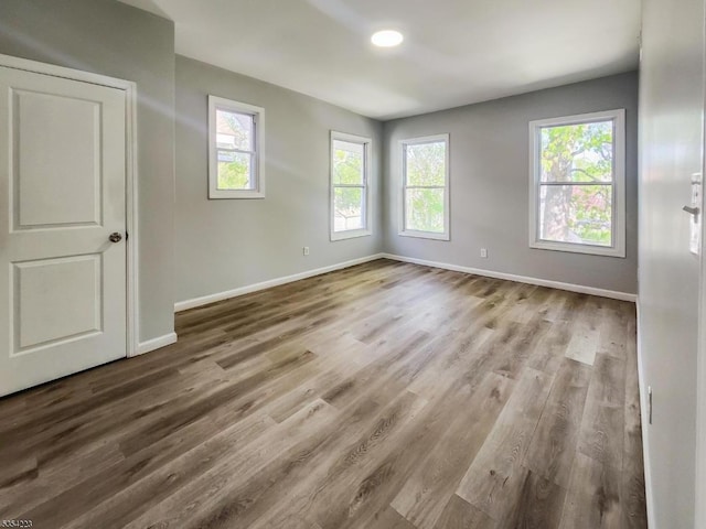 empty room with baseboards and wood finished floors