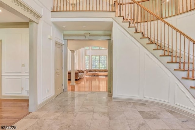 staircase featuring arched walkways and decorative columns