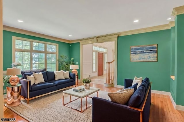 living area featuring light wood-style floors, baseboards, ornamental molding, and recessed lighting