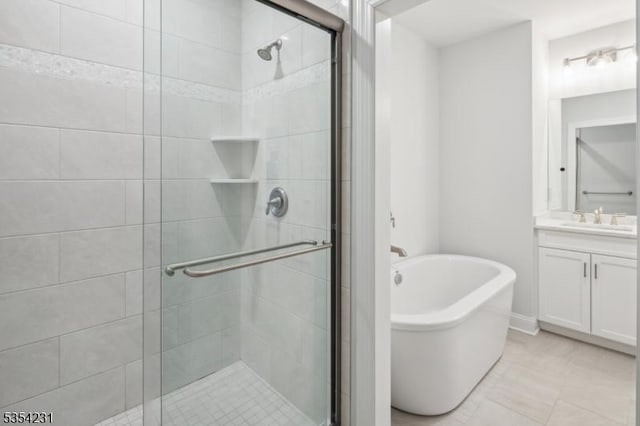 full bath with vanity, a freestanding bath, and a shower stall