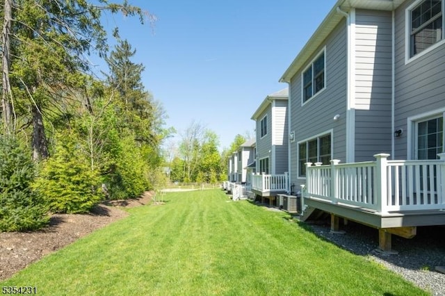 view of yard featuring a wooden deck and central AC