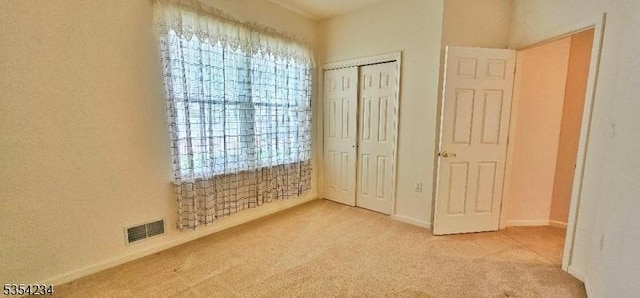 unfurnished bedroom with carpet floors, baseboards, a closet, and visible vents