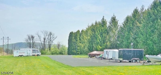 view of community featuring a yard and uncovered parking