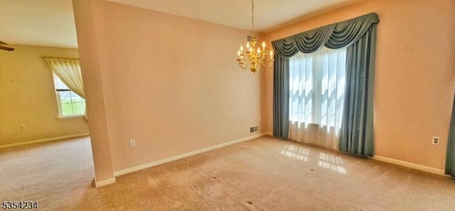 spare room with an inviting chandelier, baseboards, carpet flooring, and visible vents