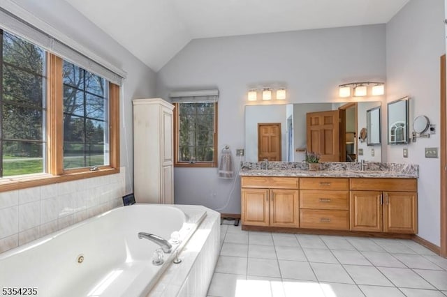 full bath featuring a sink, plenty of natural light, a jetted tub, and vaulted ceiling