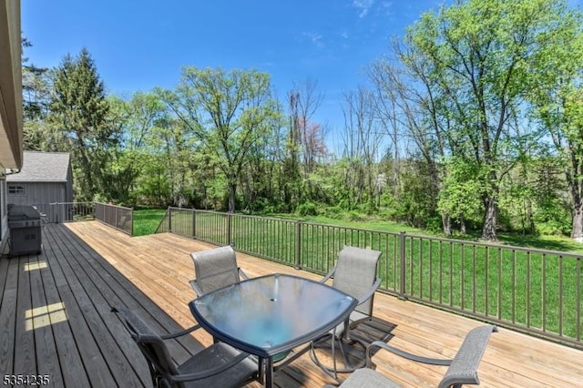 wooden terrace featuring a yard and outdoor dining area