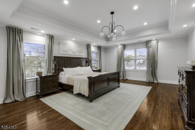 bedroom with ornamental molding, dark wood finished floors, and a tray ceiling