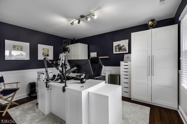 home office featuring dark wood-style floors, wainscoting, and visible vents