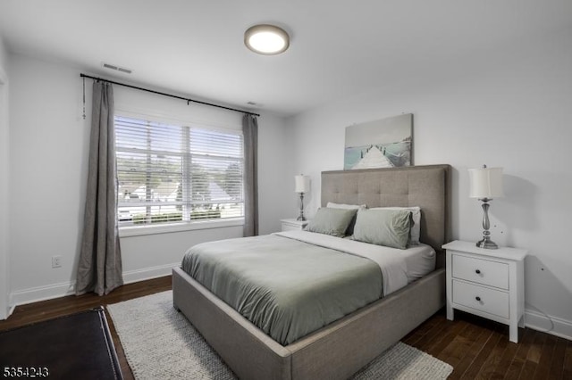 bedroom featuring visible vents, baseboards, and dark wood-type flooring