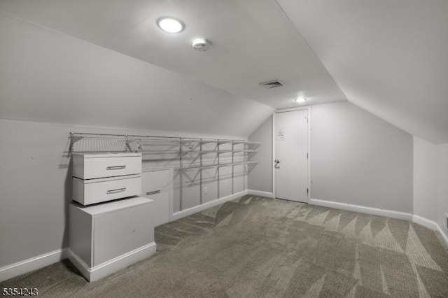 additional living space with baseboards, carpet floors, vaulted ceiling, and visible vents