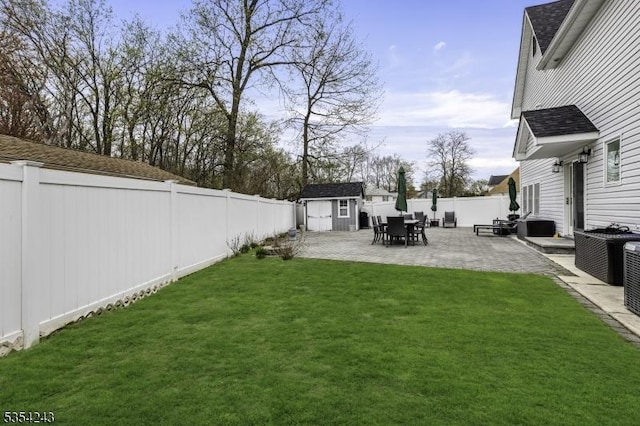view of yard with a storage unit, an outdoor structure, a patio area, and a fenced backyard