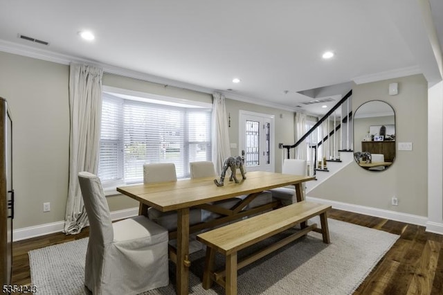 dining room featuring dark wood-style flooring, baseboards, visible vents, ornamental molding, and stairway