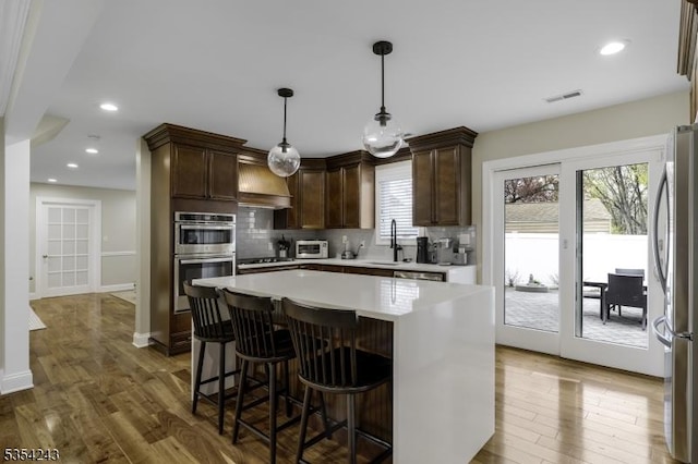 kitchen with visible vents, light countertops, appliances with stainless steel finishes, and tasteful backsplash