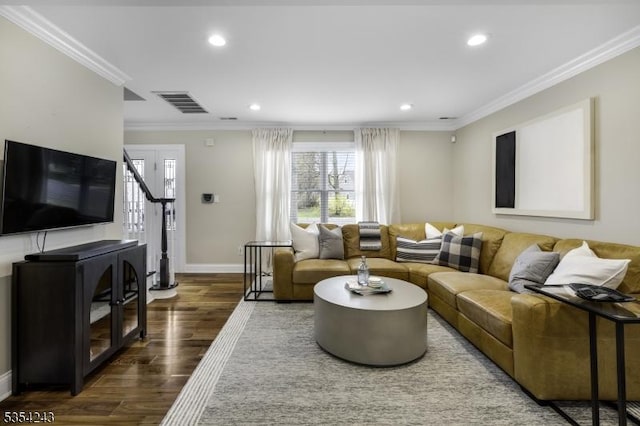 living room with crown molding, visible vents, a healthy amount of sunlight, and wood finished floors