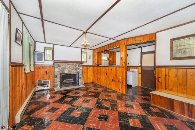 unfurnished living room featuring heating unit, a wainscoted wall, wooden walls, and a fireplace